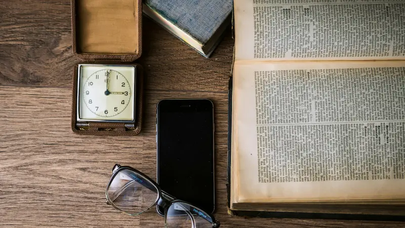 A clock showing 12:00 AM beside an open Bible.

