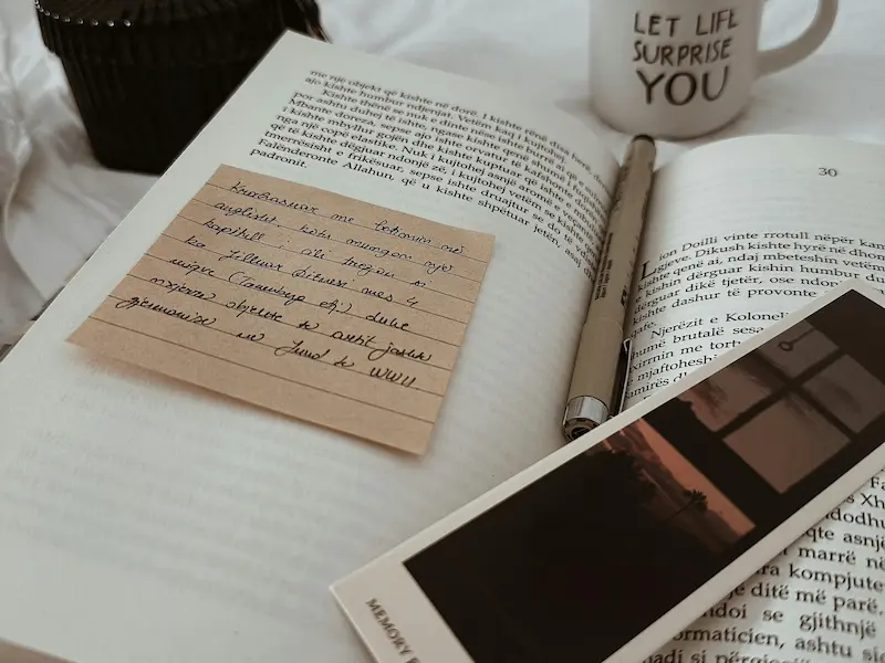 Bible, journal, and pen with coffee mug.