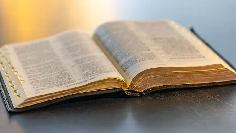 Bible open to a verse about God's forgiveness and faithfulness.