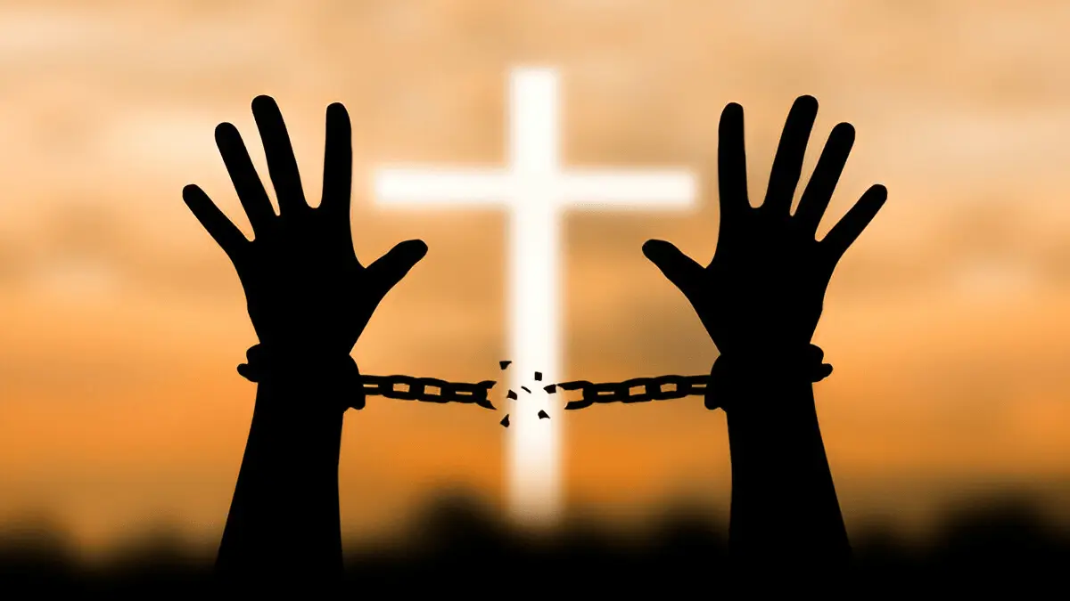Hand breaking free from metal chains, symbolizing spiritual freedom through Christ, referencing John 8:36.