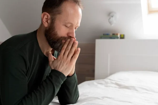 Man praying at sunrise representing daily devotion"