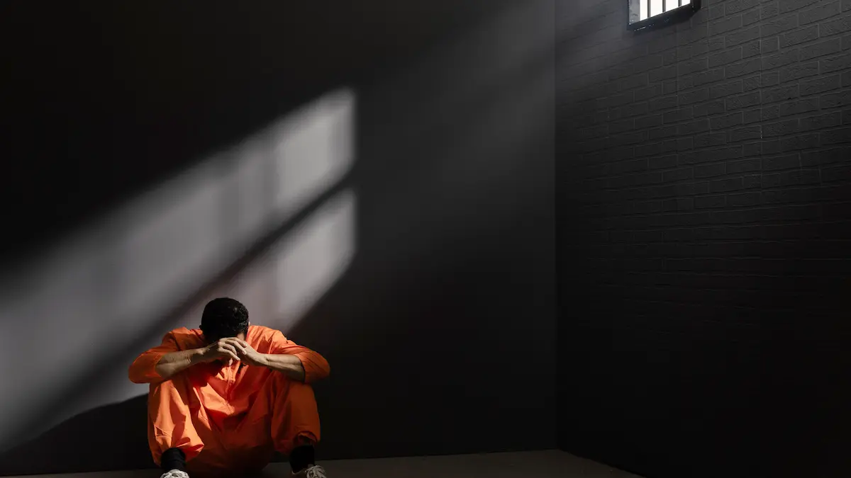 A man sitting in solitude with soft light surrounding him, representing divine presence in dark moments.