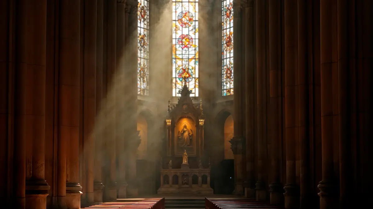 Empty wooden church pews illuminated by soft light from a stained-glass window