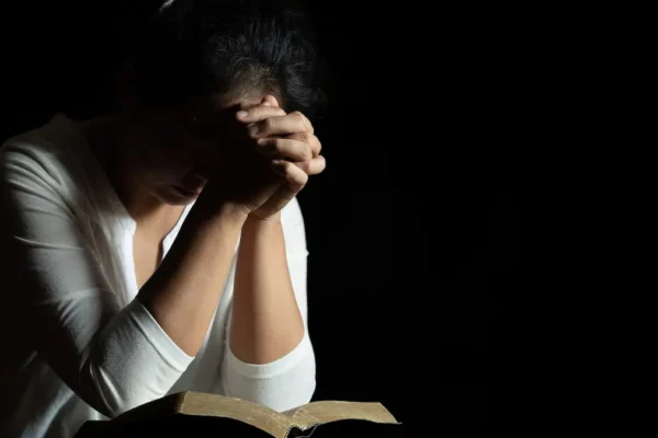 Midnight Prayers for Breakthrough: Unlocking God’s Power While the World Sleeps Person praying at midnight with bible on the laps