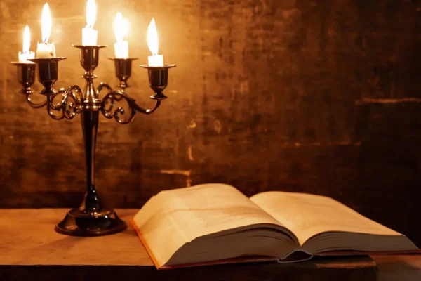 Open Bible in candlelight at midnight.