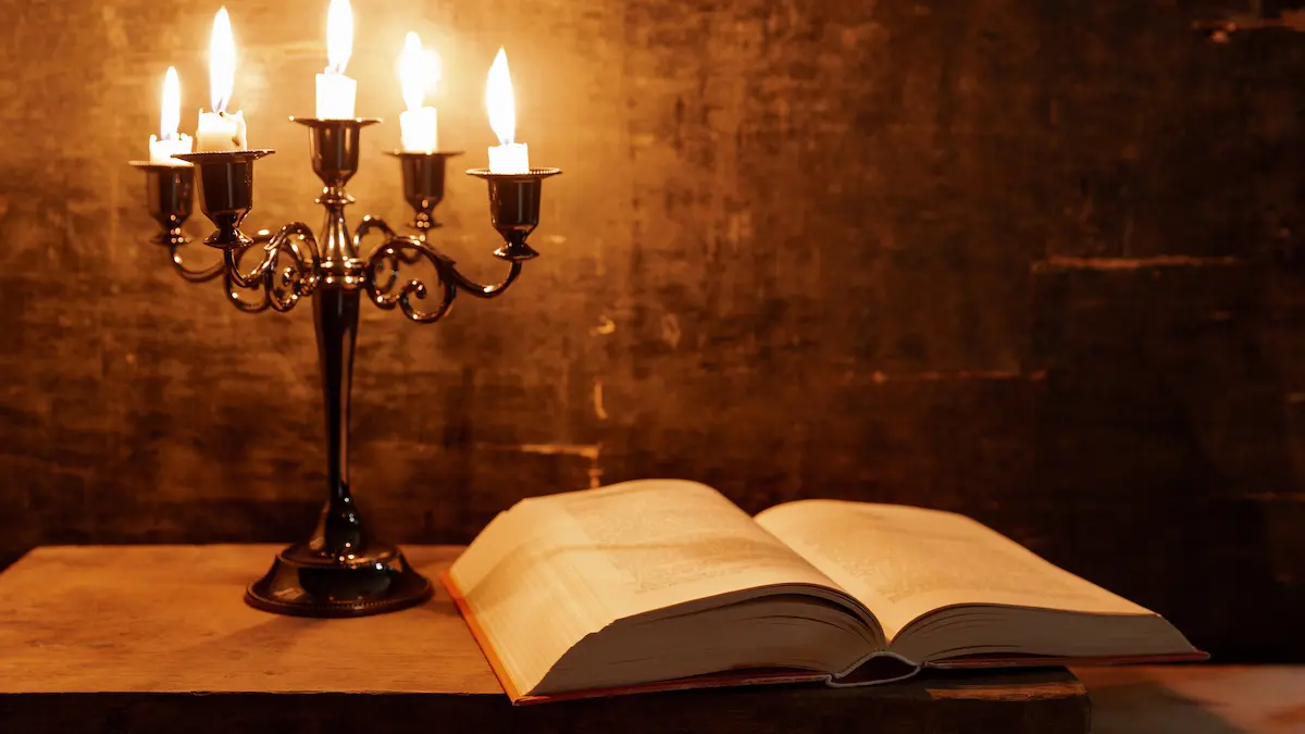 Open Bible in candlelight at midnight.
