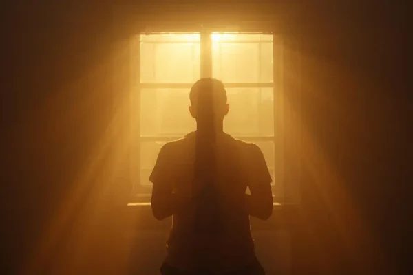 Person praying alone in sunlight during fasting