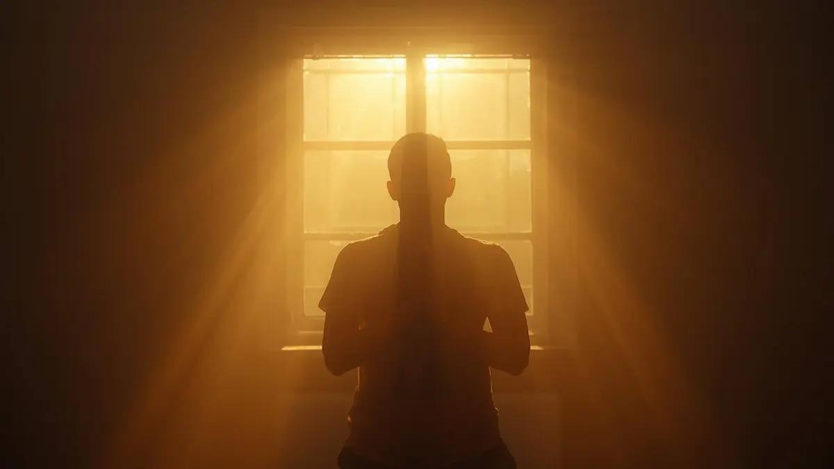 Person praying alone in sunlight during fasting