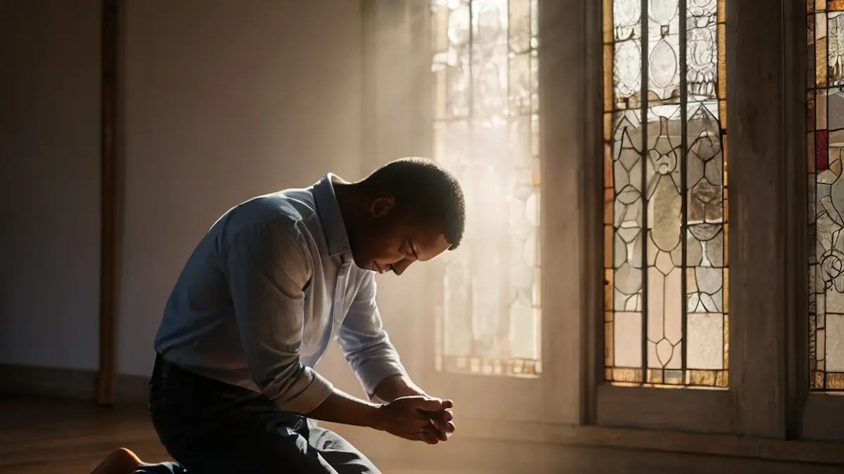 Believer praying with eyes closed and hands clasped, sunlight illuminating the space