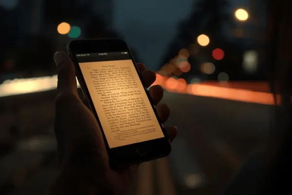 A smartphone displaying scripture, illuminating a person's face in a modern urban setting.